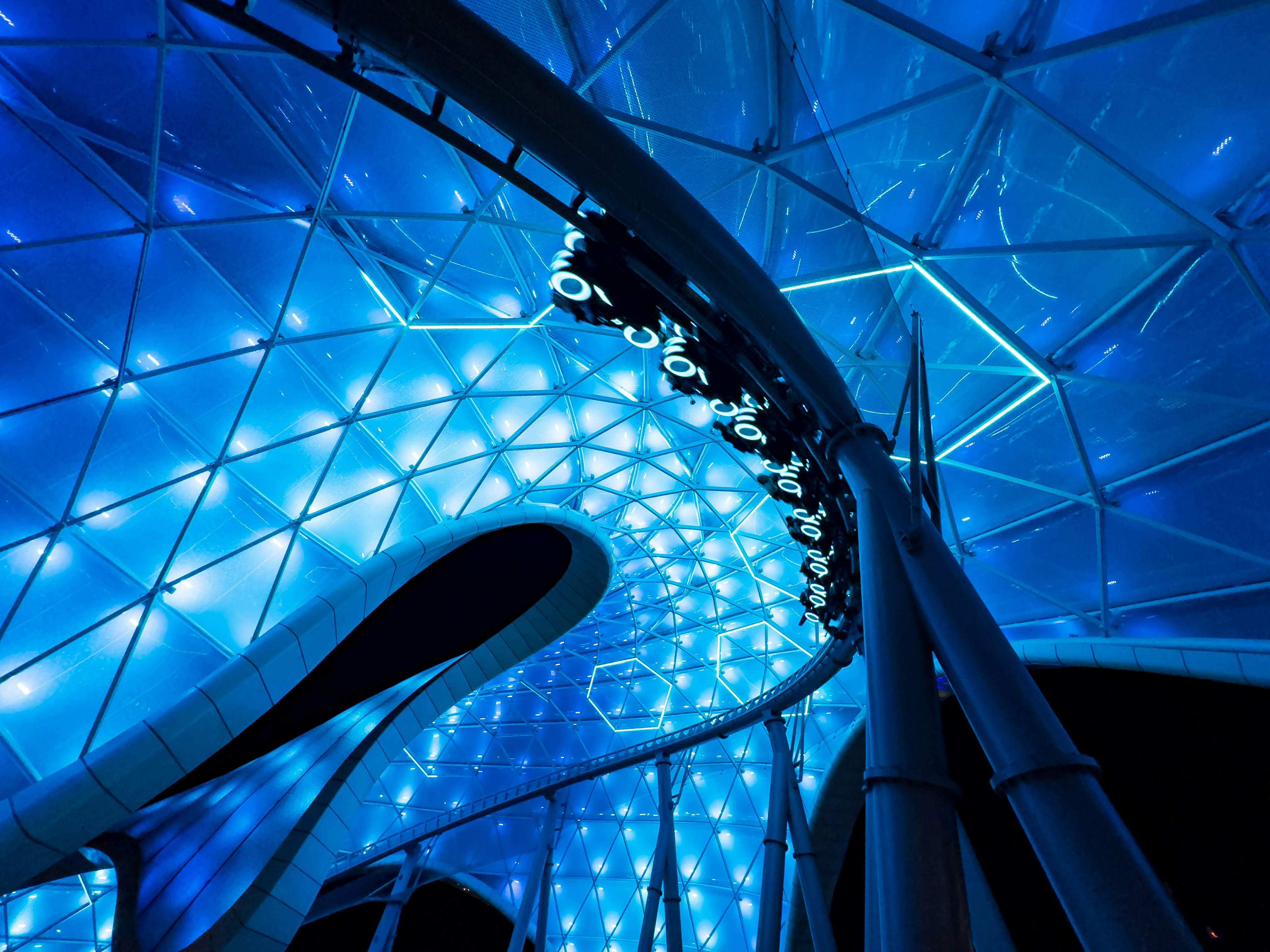 TRON Lightcycle Run coaster canopy structure illuminated in blue at night